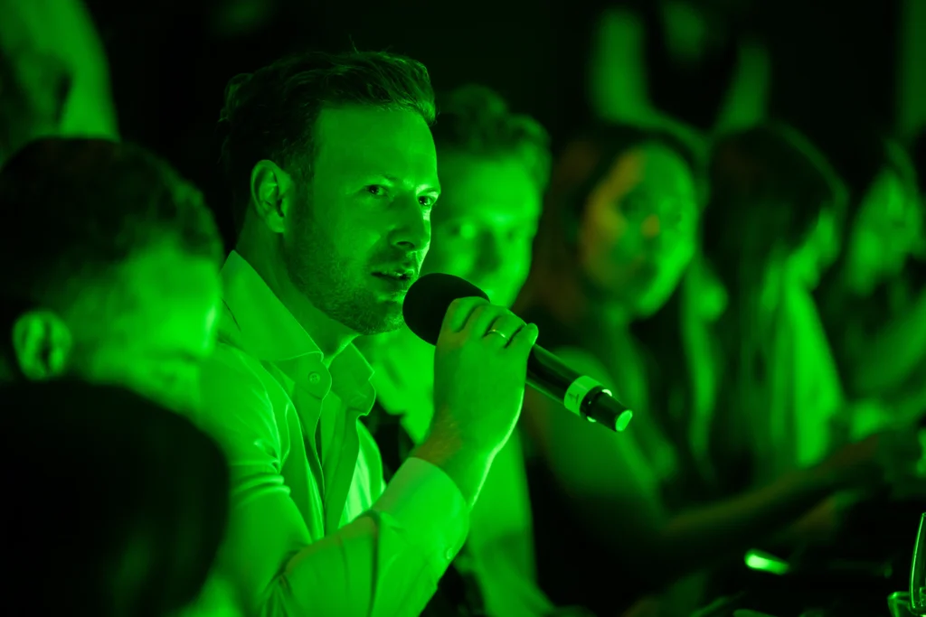 A guest speaks into a microphone to put a question to AI hologram Anna at the Pullman London dinner